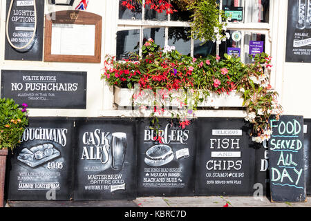 L'Angleterre, les traiter. 17e siècle King's Head Pub et inn. Tableau noir à l'extérieur publicité divers aliments sur la vente. Poisson-frites, hamburgers, plowmans. Banque D'Images