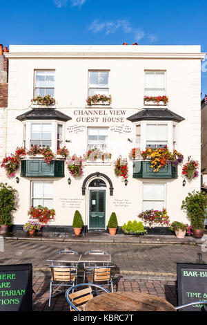 L'Angleterre, les traiter. Chambres d'hôtes en bord de mer, hotel, Channel View. Des paniers de fleurs fleurs rouge pendaison. Ciel bleu, la journée. Banque D'Images