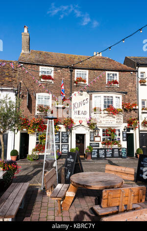 L'Angleterre, les traiter. 17e siècle King's Head Pub et inn. L'extérieur, l'avant. Les fleurs rouges dans les jardinières. Tables et bancs originaux. jour, ciel bleu. Banque D'Images