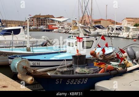 Divers câbles, seaux, boîtes, les bouées, les drapeaux et autres équipements de pêche sur un petit bateau de pêche amarré dans un port avec de nombreux autres navires de loisirs Banque D'Images