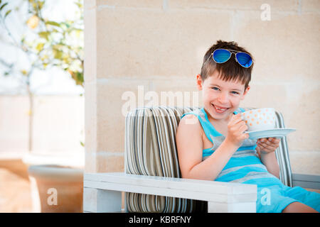 Smiling cute little boy drinking mug café thé boisson chaude Banque D'Images