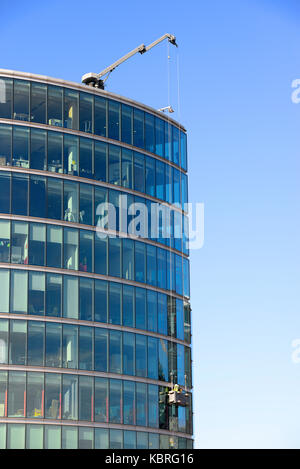 Hommes utilisant un palan de berceau sur 2 plus London Riverside bâtiment de façade de fenêtre de verre, Londres, Royaume-Uni. Ouvriers travaillant en hauteur sur un bâtiment de grande hauteur Banque D'Images