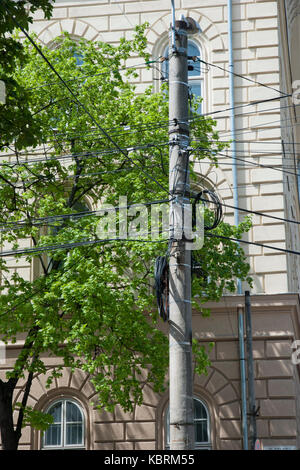 Poteau électrique avec de nombreux câbles en face de l'immeuble Banque D'Images