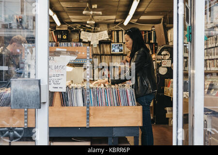 Femme parcourir les disques vinyles dans un magasin à Notting Hill, Londres. Expériences vinyle un regain d'intérêt et l'augmentation des ventes au cours des dernières années. Banque D'Images