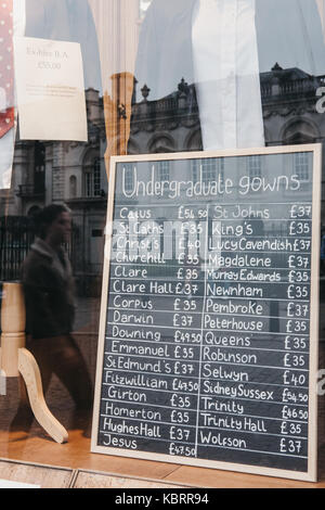 Affichage de la fenêtre de l'Université de Cambridge magasin de vêtements où les étudiants peuvent embaucher des robes de cérémonie, les prix sur un tableau noir. Banque D'Images