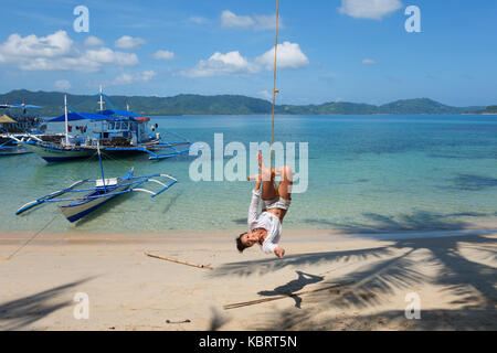 Philippines - Tourisme Le tourisme s'amusant sur une balançoire, corde, plage d'El Nido, El Nido, Palawan, Philippines, Asie Banque D'Images