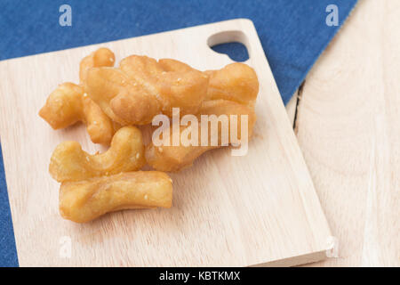 Des snacks traditionnels chinois frits (doughstick pa tong rendez) sur la plaque en bois.(soft focus) Banque D'Images