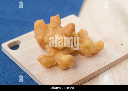 Des snacks traditionnels chinois frits (doughstick pa tong rendez) sur la plaque en bois.(soft focus) Banque D'Images