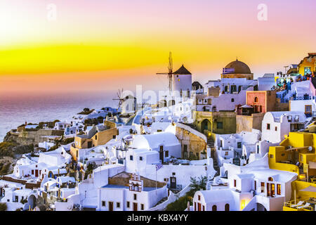 Coucher du soleil à Oia, Santorin, Grèce. et traditionnel célèbre white maisons et églises aux dômes bleus sur la caldeira, la mer Égée. Banque D'Images