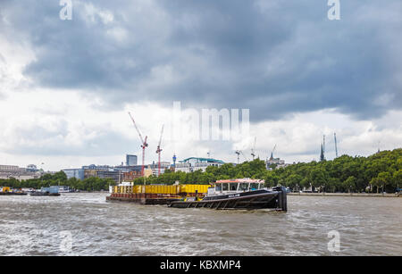 Le transport par voie navigable : Riverside CORY remorqueur de l'énergie 'Récupérer' tirant une péniche de chargement des conteneurs dans la Tamise par Victoria Embankment, London, UK Banque D'Images