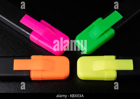Surligneur de bureau sur un fond noir. office de tirer mazak gisent sur un comptoir noir. fond noir. Banque D'Images