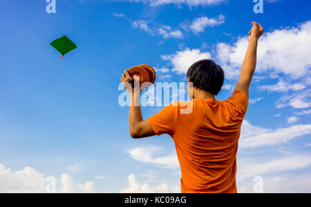 Un gars flying kite avec ciel bleu sur l'arrière-plan et copyspace Banque D'Images