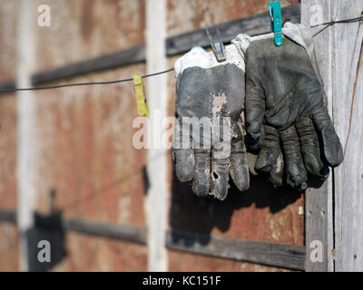Une paire de vieux gants de cuir suspendu à un fil, photo couleur sélective Banque D'Images