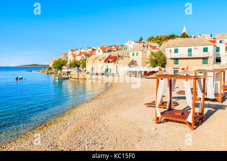 Transats sur la plage vide magnifique dans la vieille ville de Primosten, Croatie, Dalmatie Banque D'Images