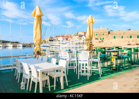 PORT DE PRIMOSTEN, CROATIE - SEP 5, 2017 : tableaux blancs avec des chaises de restaurant traditionnel en Primosten port à temps tôt le matin, la Dalmatie, Croatie Banque D'Images