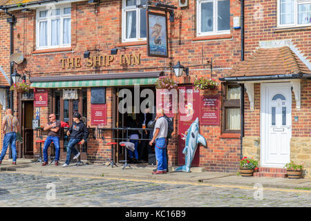 Les gens qui apprécient un verre à l'extérieur dans un pub au bord de la rue Folkestone Kent. ROYAUME-UNI Banque D'Images