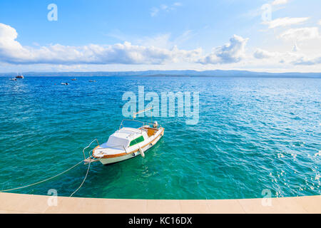 Bateau de pêche blanche sur la mer bleue et ciel ensoleillé avec des nuages blancs dans bol port, l''île de Brac, Croatie Banque D'Images