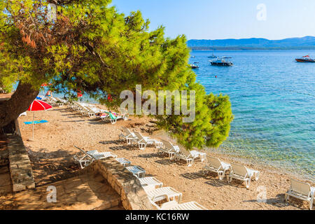 Parasols sur une plage magnifique avec la mer turquoise de l'eau dans la ville de Bol, Île de Brac, Croatie Banque D'Images