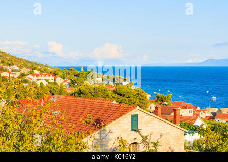 Vue d'orange, toits de maisons de la ville de bol et mer en arrière-plan, l'île de Brac, Croatie Banque D'Images