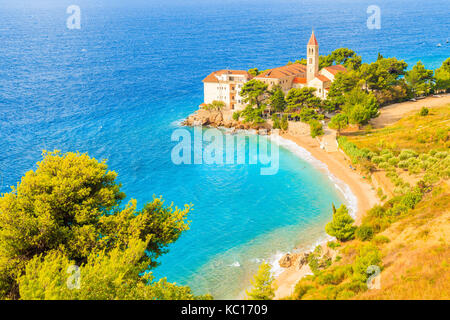 Vue sur la baie de la mer et de la plage avec le célèbre monastère dominicain de la ville de Bol, Île de Brac, Croatie Banque D'Images