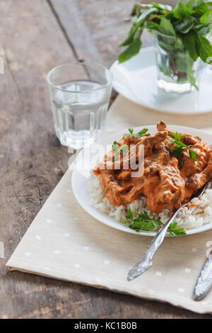 Lave riz au bœuf stroganoff sur une plaque blanche. Banque D'Images