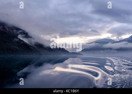 Tôt le matin étrange lumière d'automne avec brouillard, de réflexions et de nuages sur l'inversion de l'Ullswater glenridding à howtown steamer Banque D'Images