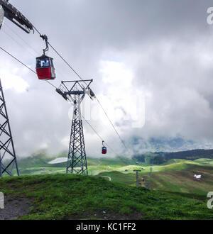 Câble rouge vers le bas à partir de la cabine mont männlichen avec vue panoramique en direction de Grindelwald, Suisse, Europe. Banque D'Images