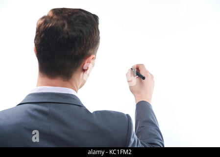 L'homme d'affaires part tenir un stylo et écrit sur un tableau blanc isolé Banque D'Images