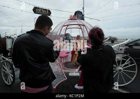 Un fier père et mère de prendre des photos de téléphone leur fille sur une calèche sur la promenade de Blackpool. credit lee ramsden / alamy Banque D'Images