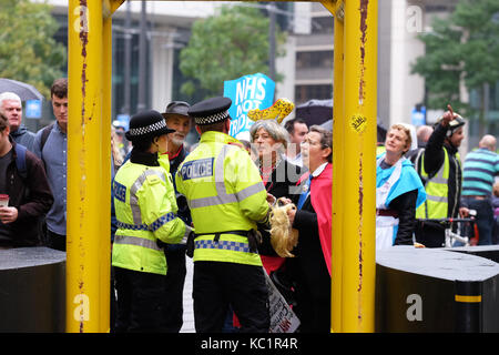 Manchester, UK. 1er octobre 2017. conservateur conférence, manchester uk, le dimanche 1er octobre 2017 - un manifestant habillé de regarder comme theresa peut parle avec la police avant d'entrer dans la zone en face de l'hôtel midland dans le centre-ville le jour de l'ouverture du congrès du parti conservateur. crédit : Steven mai/Alamy live news Banque D'Images