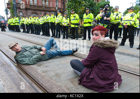 Manchester, UK. 1 octobre, 2017. Mensonge militant à travers le tramway. Ant-Fracking dusabled les militants et militantes du parti conservateur de lutte contre la sécurité de la police face à la lourde au St Peter's Square près du centre de conférence. Pro-paix, anti-austérité, les manifestations anti-guerre, y compris de rassemblements, de réunions publiques, la comédie, la musique, et de la culture, de l'avoir lieu pendant les quatre jours du congrès du parti conservateur à Manchester, au Royaume-Uni. 1er - 4e oct 2017. Credit : Graham M. Lawrence/Alamy Live News Banque D'Images