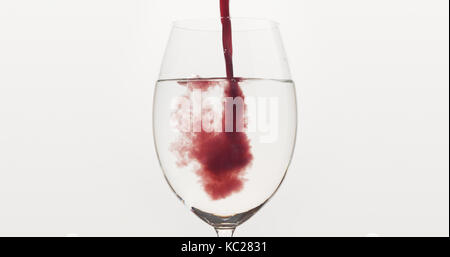 Verser le jus de bleuets dans l'eau dans un verre de vin, grande photo Banque D'Images