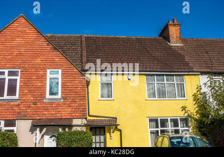 A sunlit, traditionnelle, mi-construction terrasse chambre, peint en jaune, situé sur un ancien domaine du conseil d'Ealing, London W5, Angleterre, Royaume-Uni. Banque D'Images