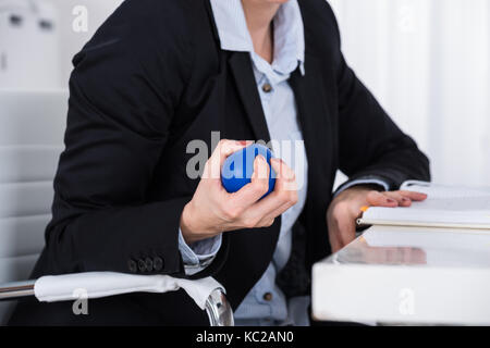 Close-up d'affaires part serrant dans la main en bleu stressball 24 Banque D'Images