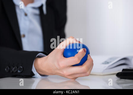 Close-up d'affaires part serrant dans la main en bleu stressball 24 Banque D'Images