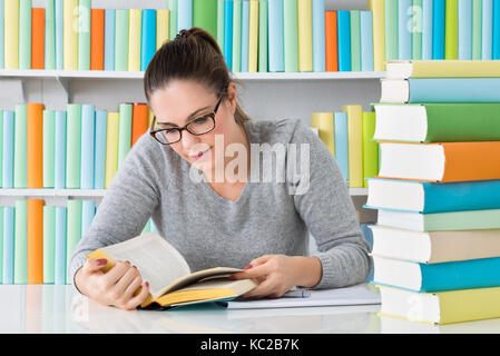 Photo de jeunes femmes Studying in Library Banque D'Images