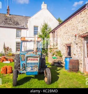 Le tracteur sur une ferme dans le Devon en Angleterre avec des sacs de pommes prêtes à être moulus. Banque D'Images