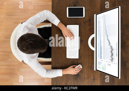 High Angle View Of Businessman Analyse Graphique sur Ordinateur de bureau Banque D'Images