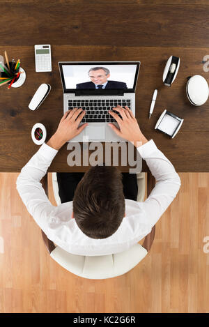 Videochatting d'affaires en ligne avec collègue sur Laptop At Desk Banque D'Images