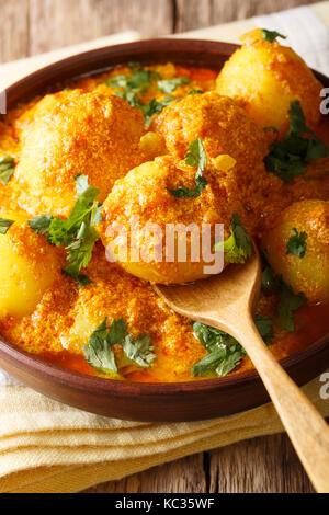 Pommes de terre épicées dum aloo dans curry sauce close-up broyeur coloïdal vertical dans un bol. Banque D'Images