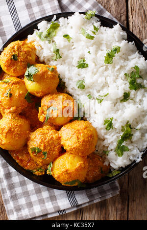 Pommes de terre épicées fraîchement préparés ou curry épicé et chaud dum aloo avec riz close-up. vertical haut Vue de dessus Banque D'Images