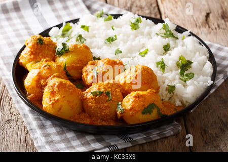 Pommes de terre au curry indien dum aloo en sauce avec du riz sur la table horizontale. Banque D'Images