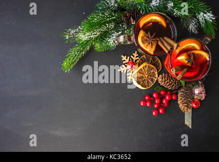 Vin chaud épicé de verre et décoration de Noël sur tableau noir avec copyspace Banque D'Images