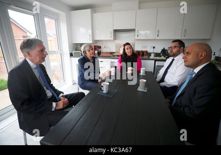 Premier ministre Theresa may, chancellor philip hammond (à gauche) et les collectivités sajid secrétaire javid (droite) Visitez la maison de Rebecca coulton à Manchester au cours de la conférence du parti conservateur dans la ville. Banque D'Images