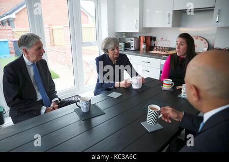 Premier ministre Theresa may, chancellor philip hammond (à gauche) et les collectivités sajid secrétaire javid (droite) Visitez la maison de Rebecca coulton à Manchester au cours de la conférence du parti conservateur dans la ville. Banque D'Images