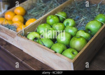Boîte en bois avec des pommes vertes sur l'écran dans un magasin de fruits Banque D'Images