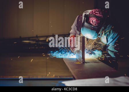 Soudeur industriel avec une torche et casque de protection en grande salle welding metal adulte Banque D'Images