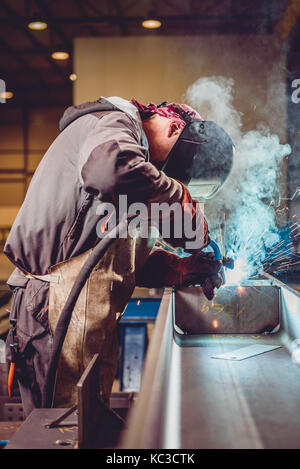 Soudeur industriel avec une torche et casque de protection en grande salle welding metal adulte Banque D'Images