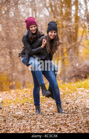 Deux laughing girl jouer à l'extérieur dans le parc en automne Banque D'Images