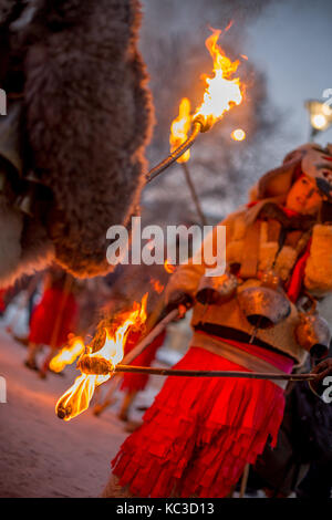 Pernik, Bulgarie - 27 janvier 2017 : les participants masqués dans scary costumes de fourrure passent le feu à l'autre, les torches à surva fest international Banque D'Images